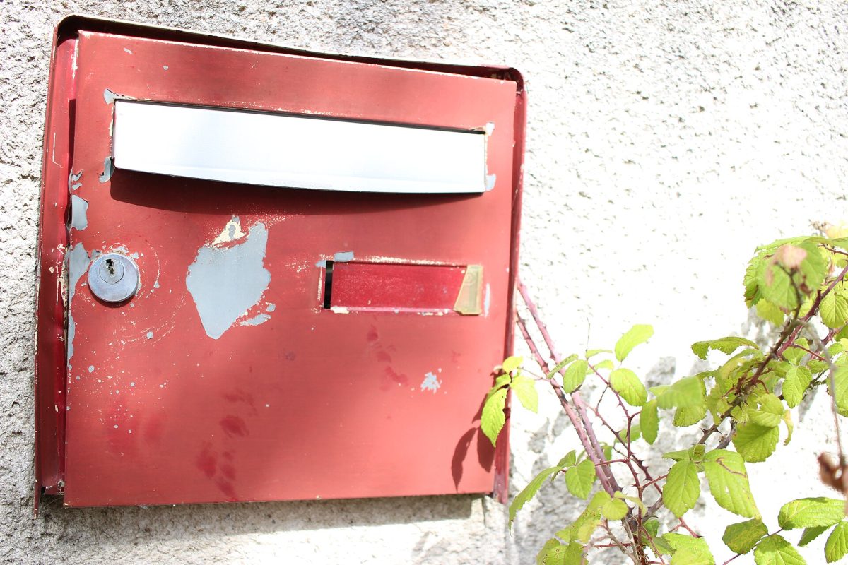 Vieille boîte aux lettres rouge fixée à un mur